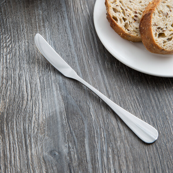 A plate of bread with a Libbey stainless steel butter knife.
