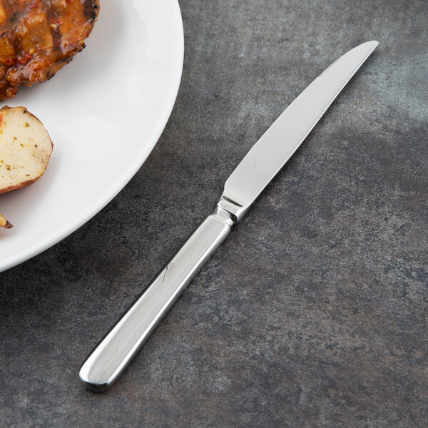 A plate of food with a Libbey Baguette steak knife on it.