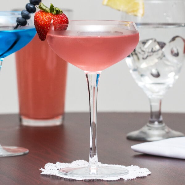 A Reserve by Libbey coupe glass with pink liquid and a strawberry garnish.