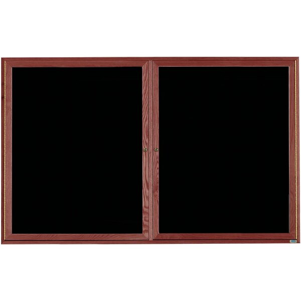 An Aarco black felt message board with a cherry wood frame and 2 black glass doors.