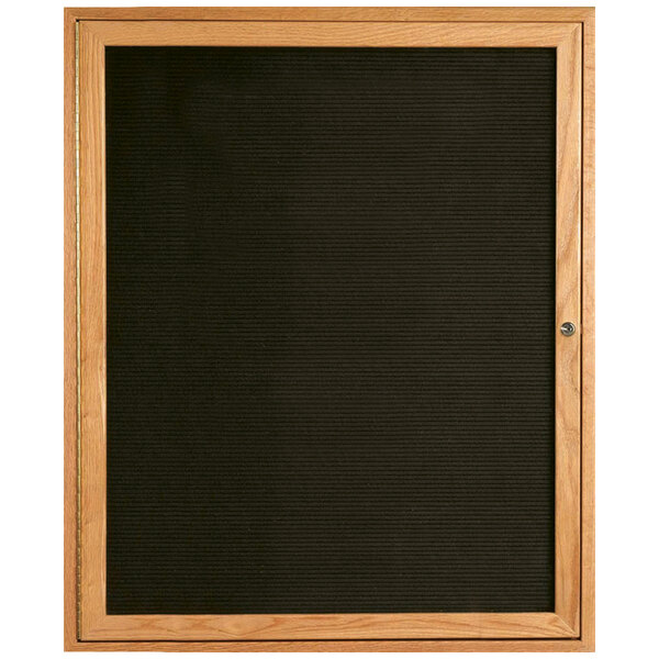 An Aarco enclosed wooden framed bulletin board with a black felt interior.