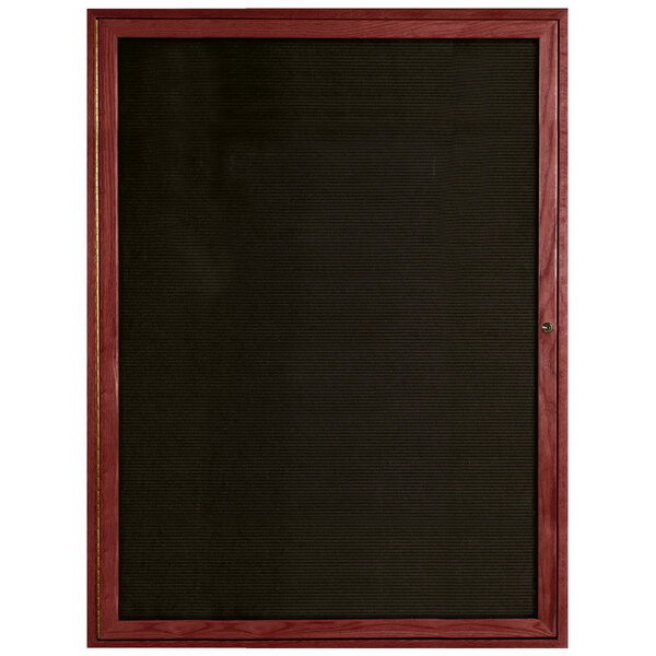 An enclosed Aarco cherry wood message board with black trim.
