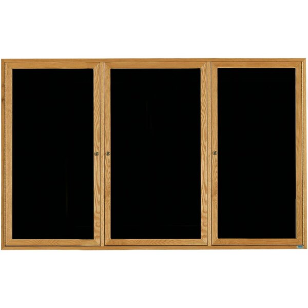 A wooden message board with black felt and three glass doors on a wooden frame.