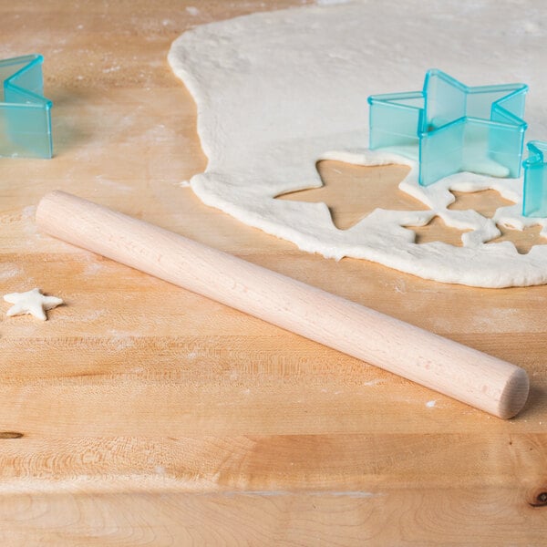A Thunder Group wood dowel rolling pin on a wooden table.