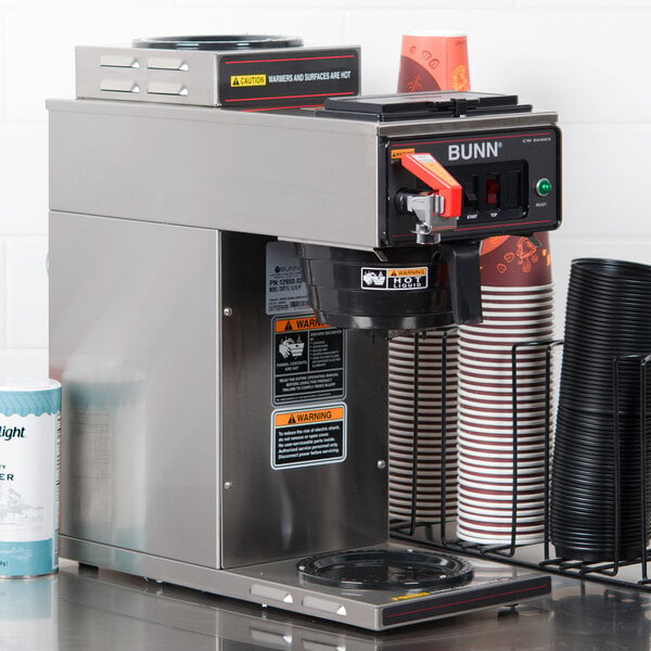 A Bunn automatic coffee machine with cups on top.
