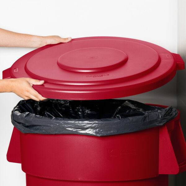 A close-up of a red lid on a Carlisle Bronco trash can.