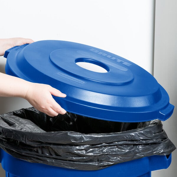 A hand putting a blue Rubbermaid BRUTE lid on a blue container.