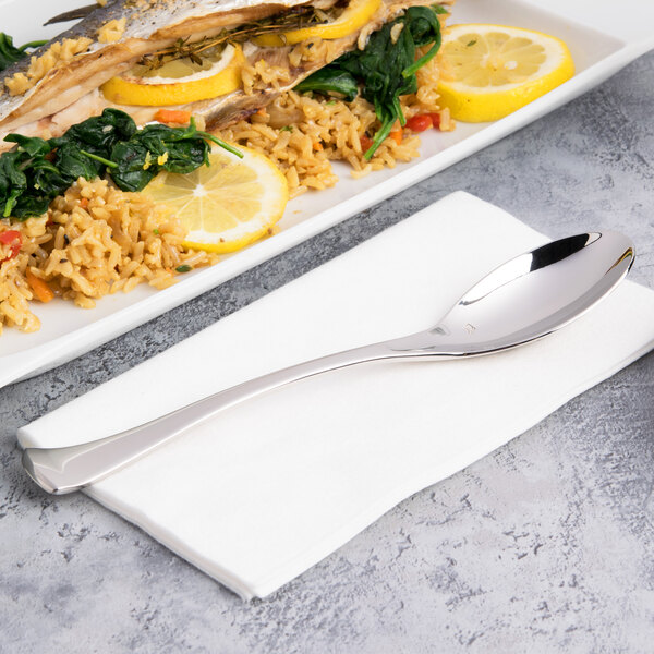 A plate of food with a Chef & Sommelier stainless steel dinner spoon and fork, and lemon slices and rice.