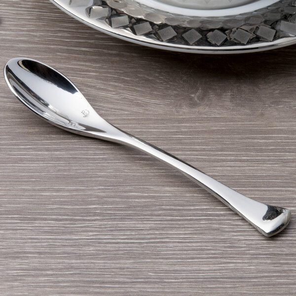 A Chef & Sommelier stainless steel demitasse spoon with a silver handle on a table.