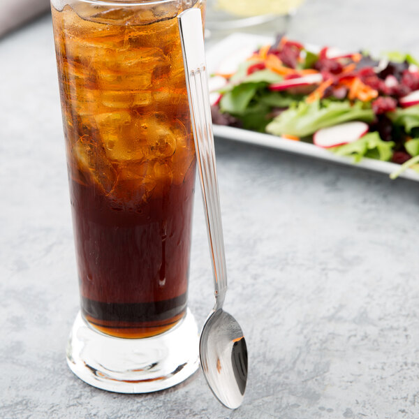 A glass of iced tea with Libbey iced tea spoon on a table.