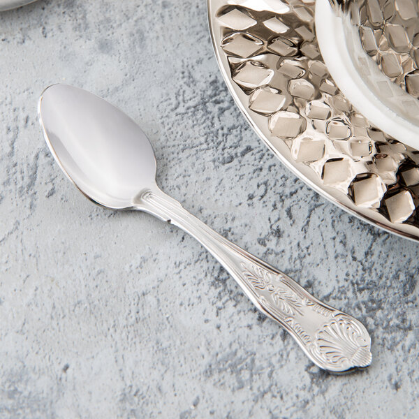 A Libbey stainless steel demitasse spoon on a white plate.