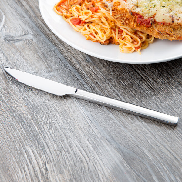 A plate of spaghetti and meat with a Libbey Elexa stainless steel dinner knife.