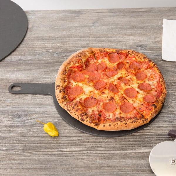 An Epicurean slate pizza board with a pepperoni pizza on it.