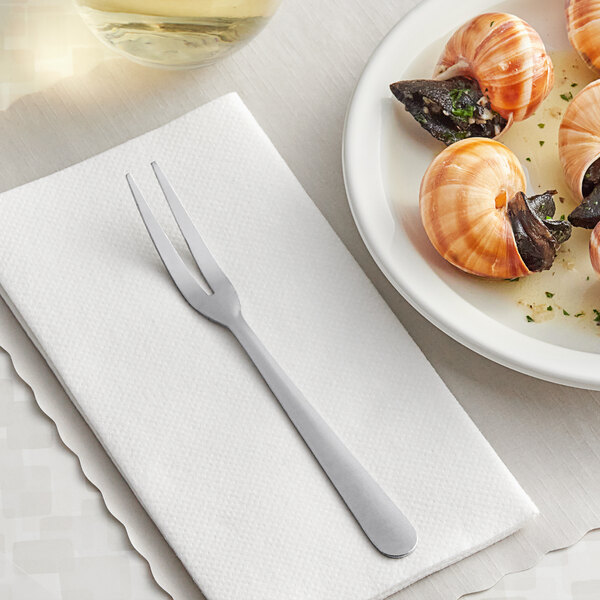 A plate of snails with Choice Windsor stainless steel snail forks on a white surface.