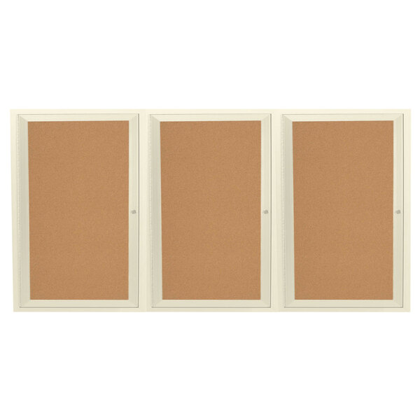 A white rectangular indoor bulletin board cabinet with three doors enclosing three cork bulletin boards.