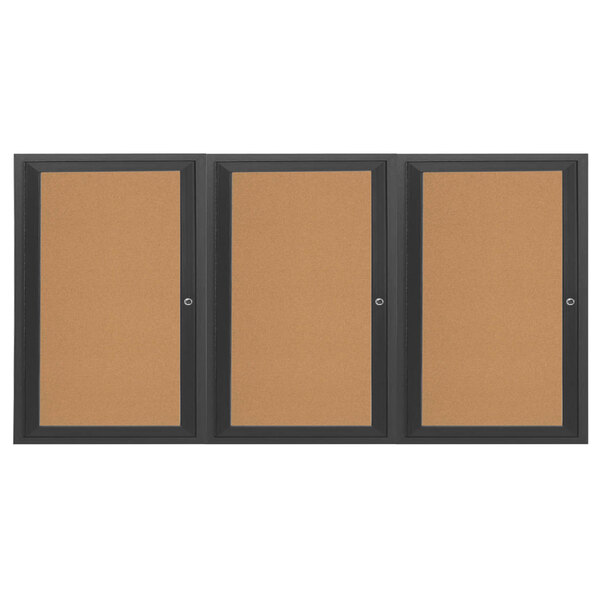 A brown board with black frame and three doors enclosing three black bulletin boards.
