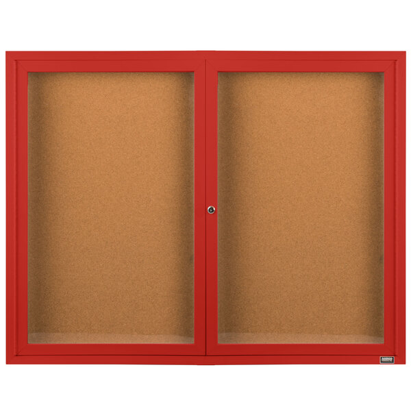 A red Aarco bulletin board cabinet with two glass doors enclosing cork boards.