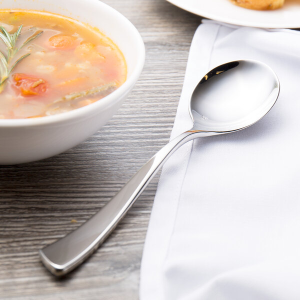 A bowl of soup with a Chef & Sommelier stainless steel soup spoon next to it.