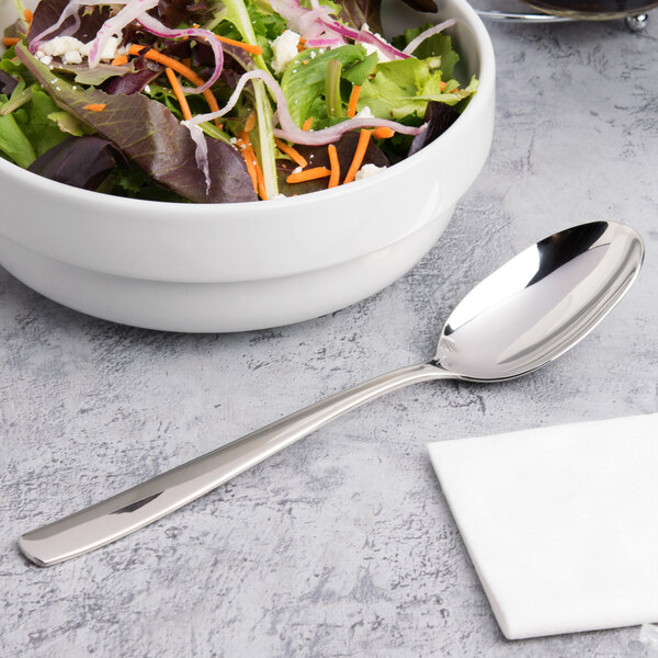 A bowl of salad with a serving spoon.