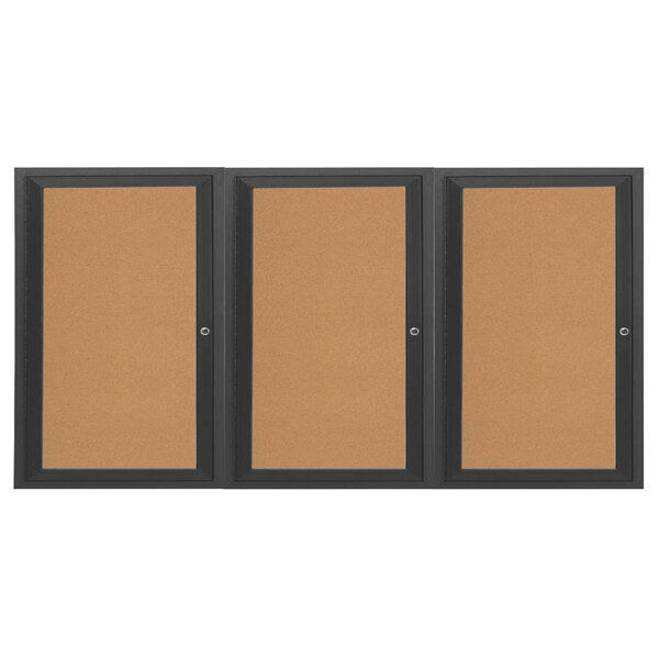 A brown bulletin board cabinet with black frames on three doors containing three cork bulletin boards.