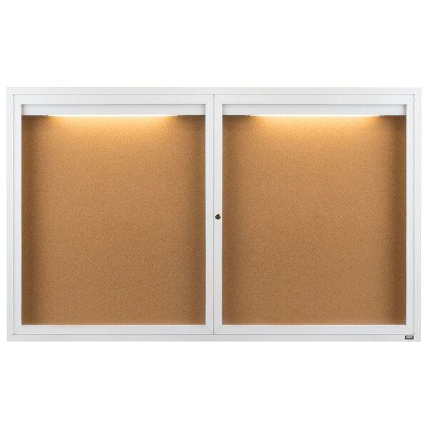 A white Aarco enclosed bulletin board with lights.