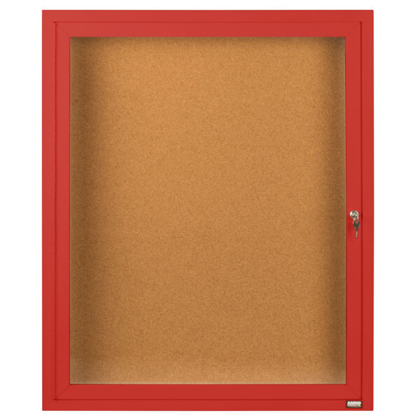 A red framed Aarco indoor bulletin board cabinet with a glass door and key lock.