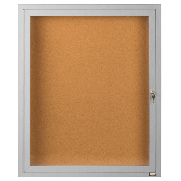 An Aarco satin anodized indoor bulletin board cabinet with a white frame and glass door.