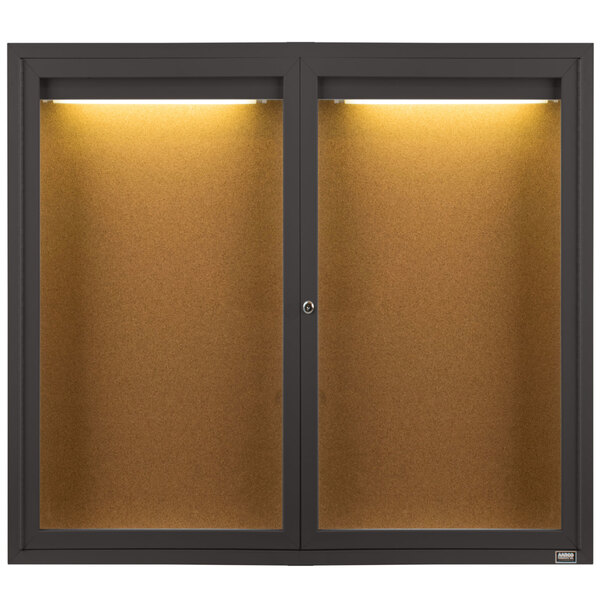 An Aarco bronze indoor bulletin board cabinet with lights.