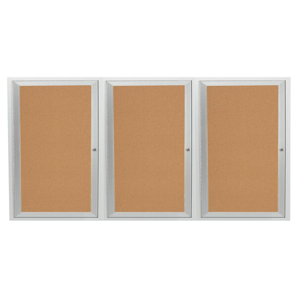 A white satin anodized enclosed bulletin board cabinet with three doors.