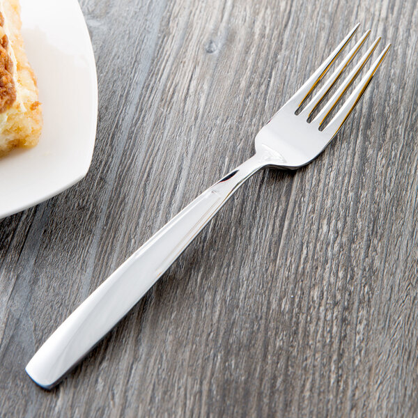 A Libbey stainless steel dessert fork on a white plate.