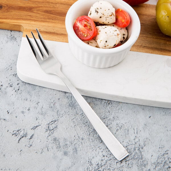 A Libbey stainless steel cocktail fork in a bowl of mozzarella and tomatoes.