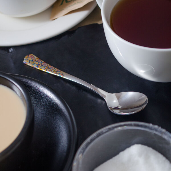 A white table with a cup of tea and a Master's Gauge stainless steel demitasse spoon.