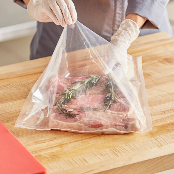 A person holding a plastic bag of meat.