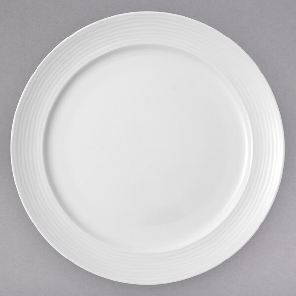 A close up of a Villeroy & Boch white porcelain plate with a curved edge and thin rim.