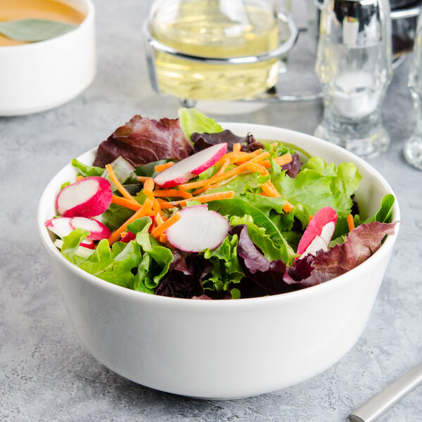 A Villeroy & Boch white porcelain bowl filled with salad with radishes and carrots.