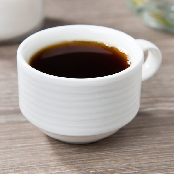 A close up of a Villeroy & Boch white porcelain cup of coffee on a table.