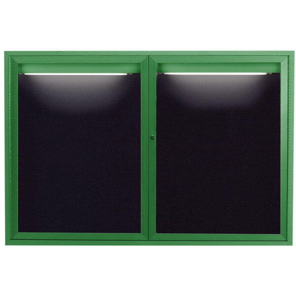 A green aluminum enclosed bulletin board with black letter board and two lights.