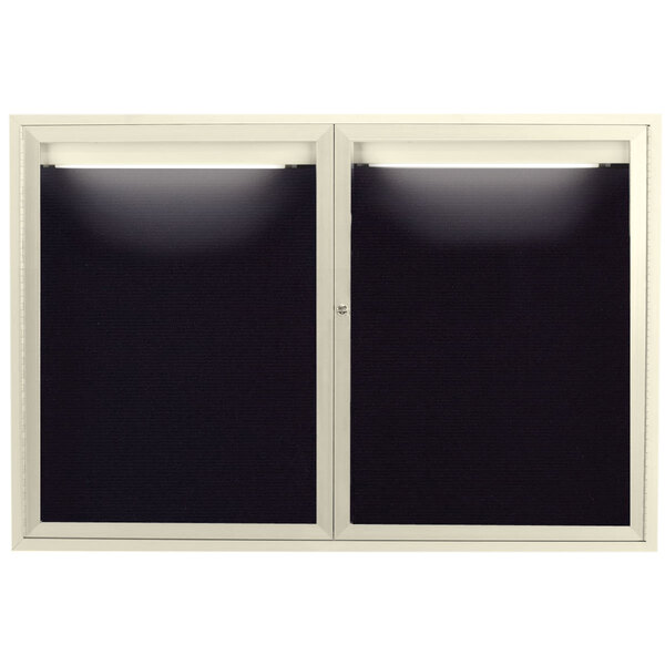 A pair of ivory aluminum doors with black letter board windows and white lights.