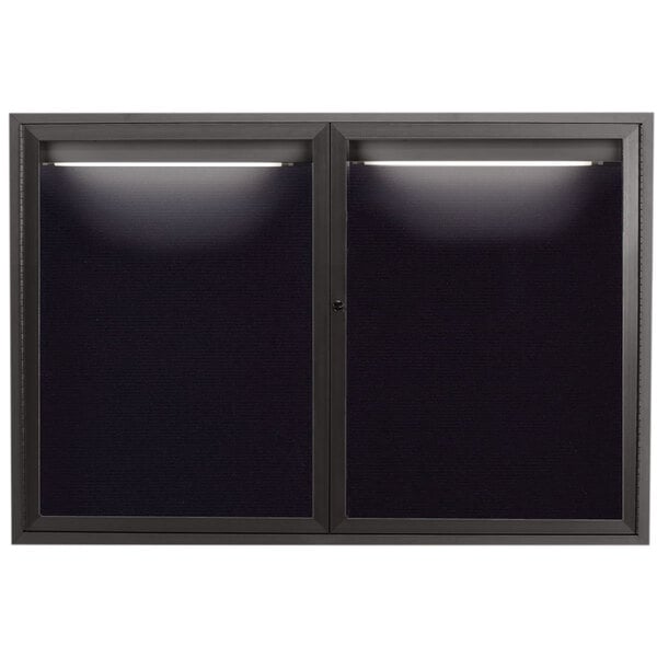 A black rectangular glass door with lights and a black letter board inside.