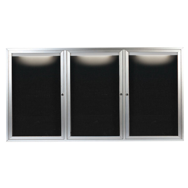 A black rectangular message center with a silver metal frame and three black cabinet doors with glass panels.