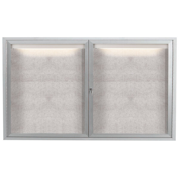 A white rectangular Aarco outdoor bulletin board cabinet with two glass doors and a light above them.