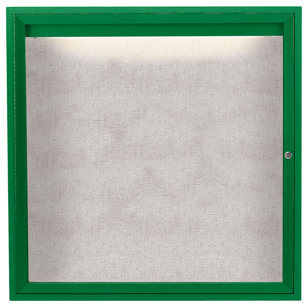 A green framed enclosed outdoor lighted bulletin board with a white interior.
