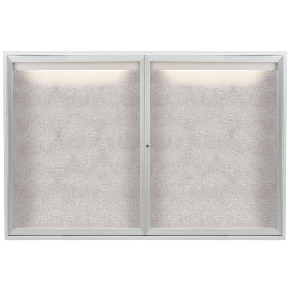 A white framed enclosed bulletin board with lights on the inside.