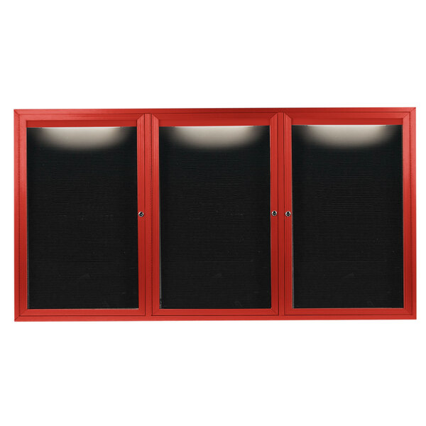 A red cabinet with black doors containing a black rectangular message board with red borders.