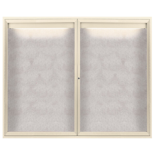An ivory enclosed bulletin board with 2 doors and a white metal frame.