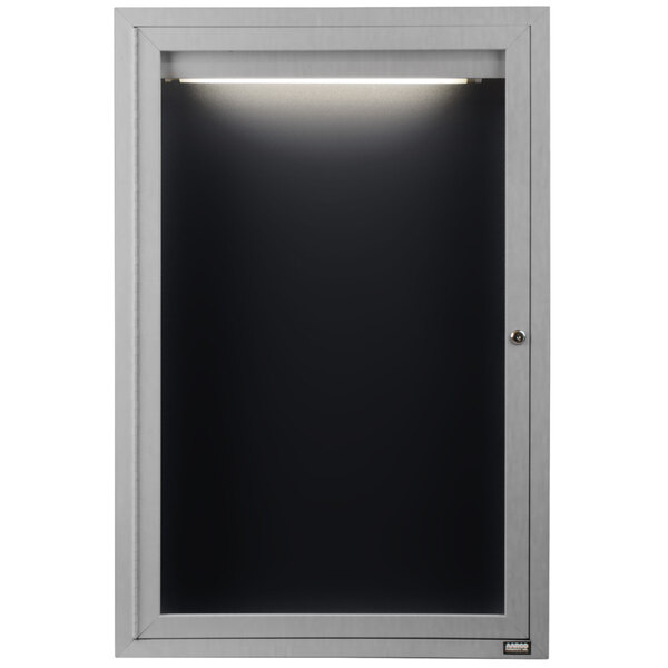 A black rectangular Aarco indoor message center with a light on it and a black letter board inside.