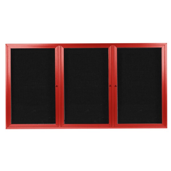 A black rectangular message center with red frames on three doors and a black letter board inside.