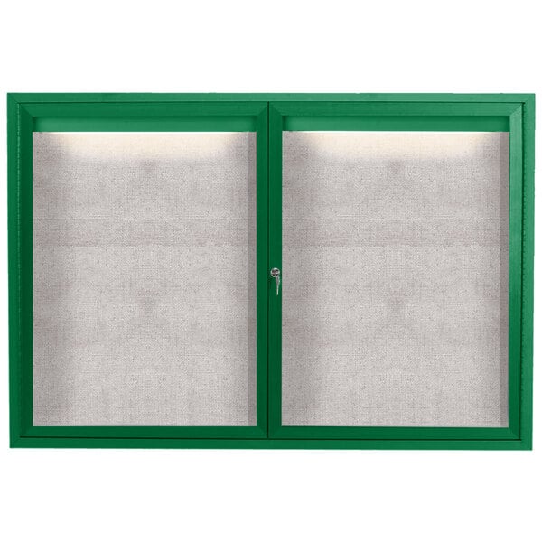 A green powder coated bulletin board cabinet with two doors and a white interior.