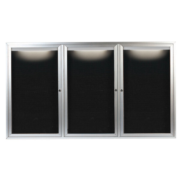 A black rectangular object with a silver frame and three black letter boards behind glass doors.