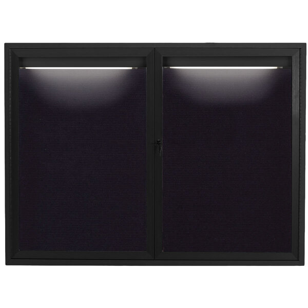 A black rectangular bulletin board with two lights on the top.